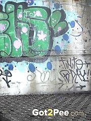 15 pictures - Sexy brunette pisses in the city on drain pipe