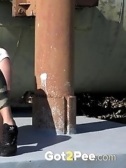 15 pictures - Busty brunette pissing on an industrial area
