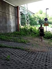 15 pictures - Sexy brunette pisses in the city on drain pipe