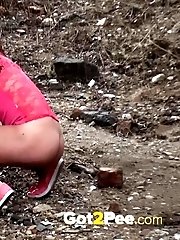 15 pictures - Pretty girl crouches on the soil to pee